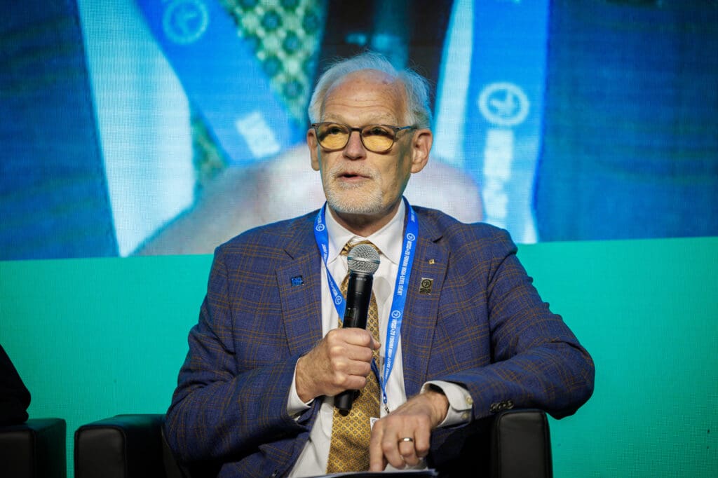 2024 IEEE President Tom Coughlin holding a microphone while speaking at the WSIS+20 Forum.