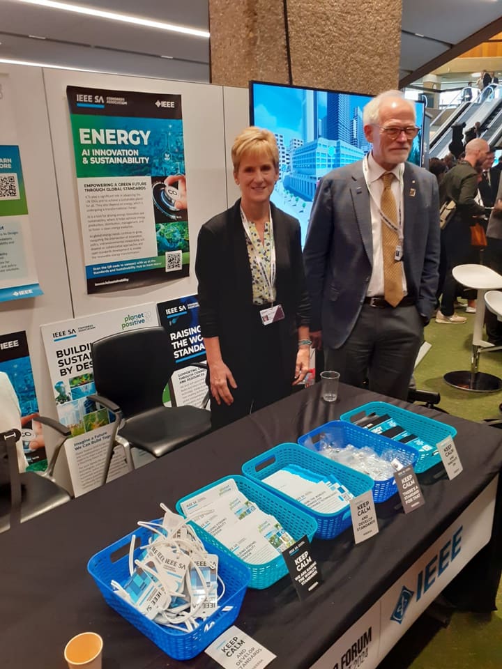 Karen McCabe and Tom Coughlin standing at the IEEE booth at the WSIS+20 Forum.