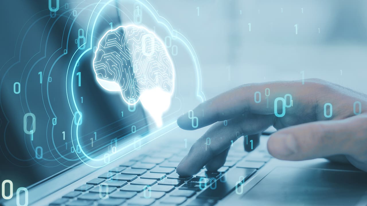 Image of a brain and binary code coming out of a laptop.